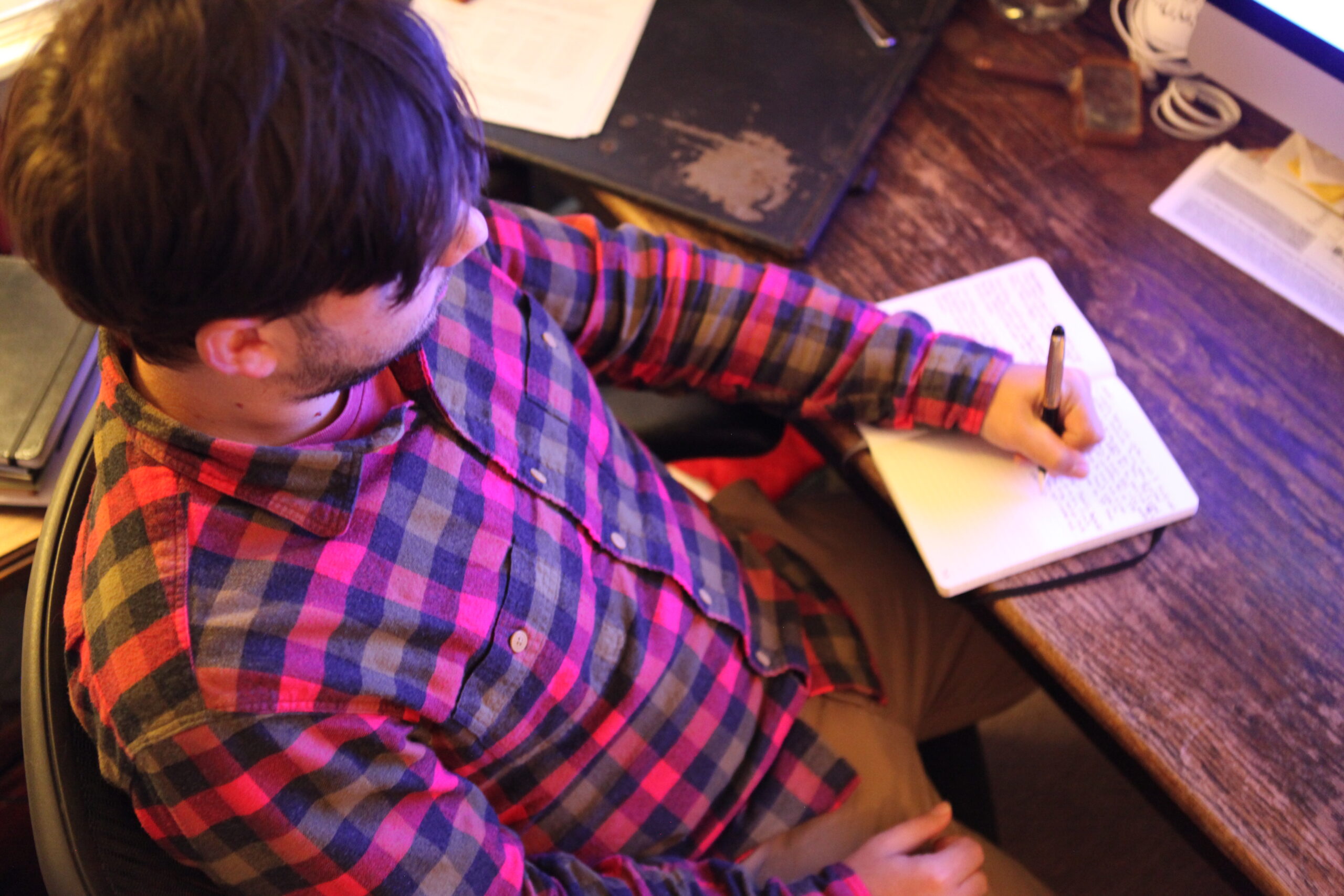 eric shay howard writing in notebook on desk